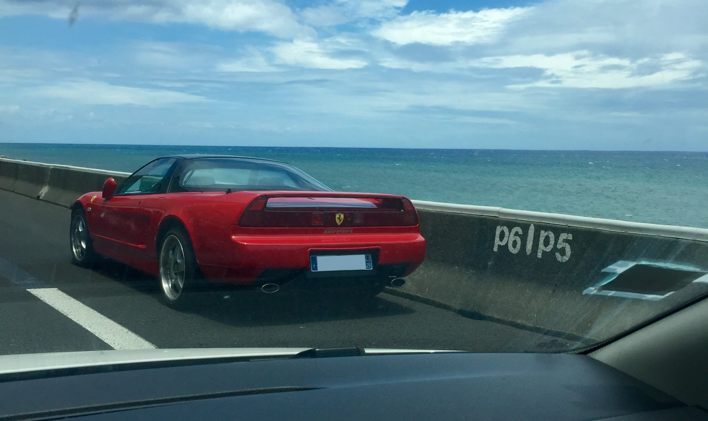 Une Ferrari en panne sur la route en corniche